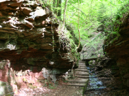 Wanderweg teilweise entlang des Bachs mit rotbraunen teils überhängenden Felswänden zu beiden Seiten. Wanderweg teilweise entlang des Bachs mit rotbraunen teils überhängenden Felswänden zu beiden Seiten.