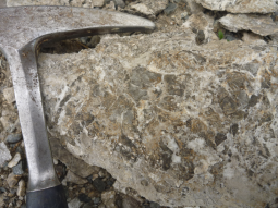 Braun, graues Gestein und einen Hammer links. Braun, graues Gestein und einen Hammer links.